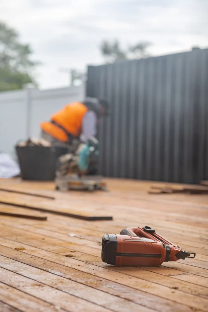 Man working on fence with a sander